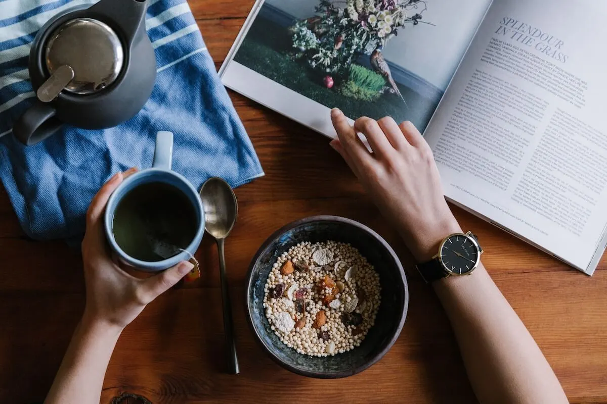 Person eating breakfast while reading a magazine