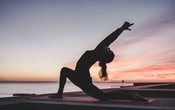 A woman practicing yoga post-holidays to enhance mental clarity, brain health, and physical well-being